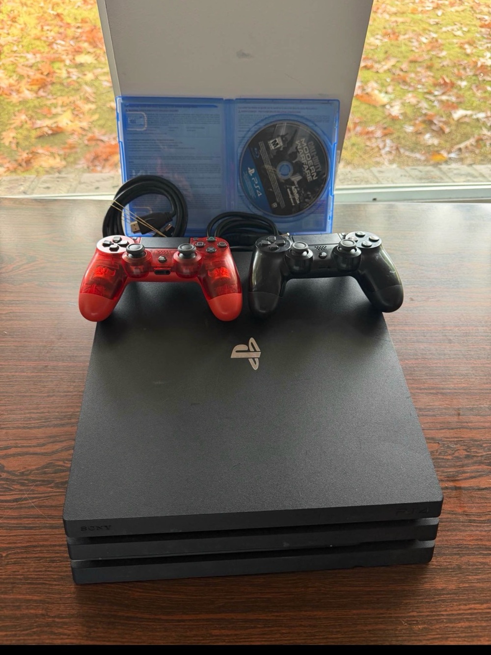 Sony PlayStation 4 Pro with Red and Black DualShock Controllers